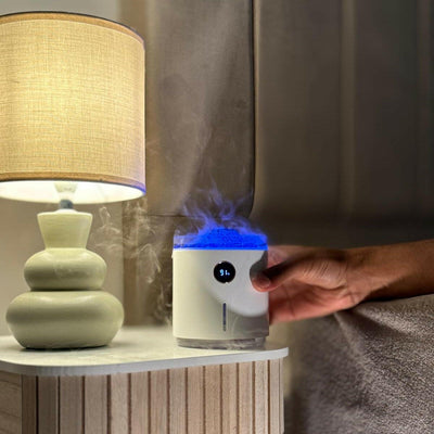 Diffuseur d'huiles essentielles volcan avec LED allumées, posé sur une table de chevet dans la chambre