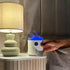 Diffuseur d'huiles essentielles volcan avec LED allumées, posé sur une table de chevet dans la chambre