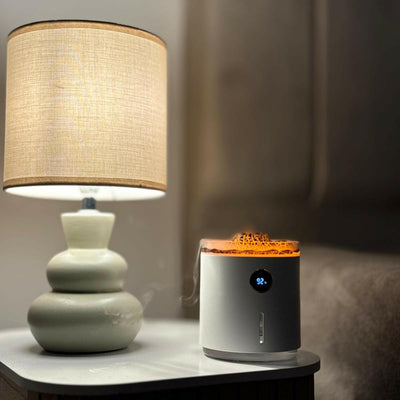 Diffuseur d'huiles essentielles volcan avec LED allumées, servant de veilleuse, posé sur une table de chevet dans la chambre